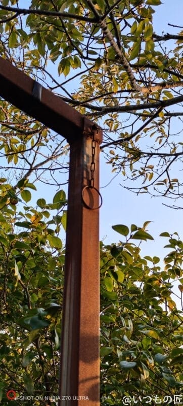 屋外で鉄の柱と木々を撮影した写真 | モバイル比較レビュー.jp nubia Z70 Ultra カメラ 屋外で鉄の柱と木々を撮影した写真