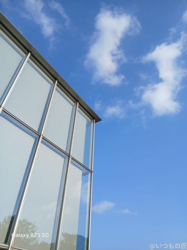 晴天下で撮影したガラス張りの建物の写真 | モバイル比較レビュー.jp Galaxy A25 5G カメラ 晴天下で撮影したガラス張りの建物の写真